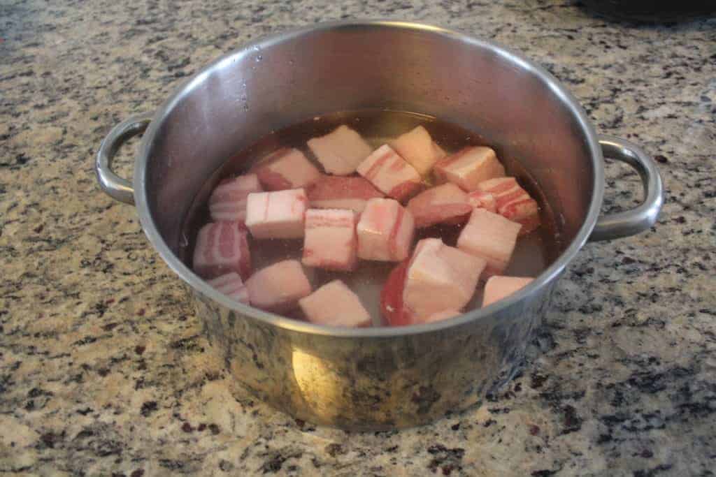 A pot filled with pork belly cubes and water