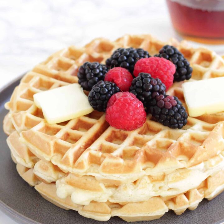 Close up of fluffy waffles with butter and berries