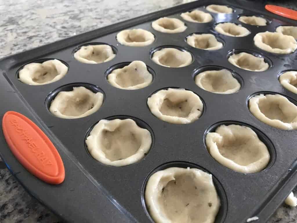 Sugar cookie dough in mini muffin pan.