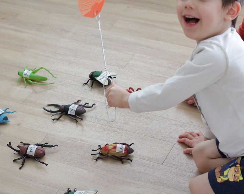 A boy smacking bugs with a fly swatter