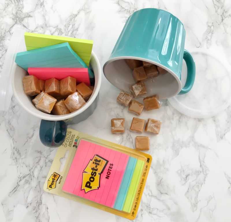 Two mugs filled with candy and Post-its