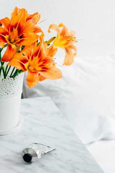 Vivid orange flowers next to a bed
