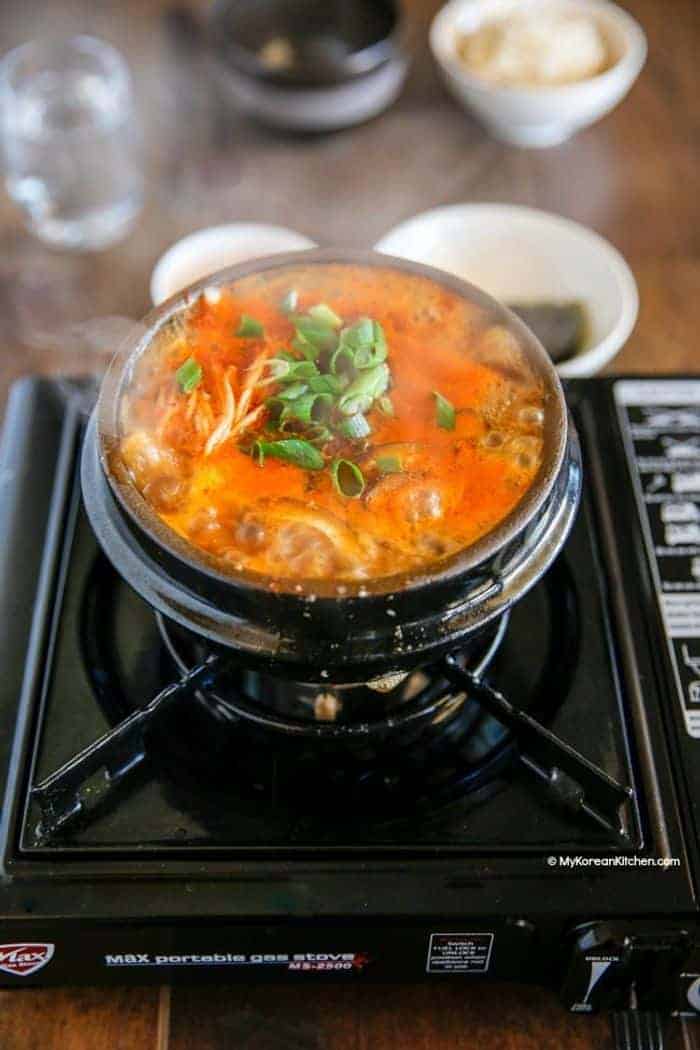A bowl of Korean stew on a burner 