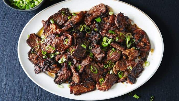 A plate full of bulgogi and scallions