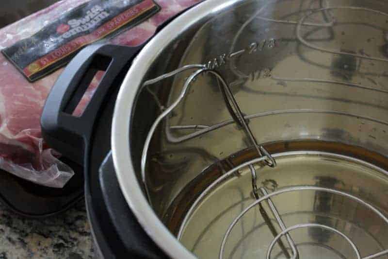 Putting trivet, water, and apple cider vinegar in Instant Pot for ribs