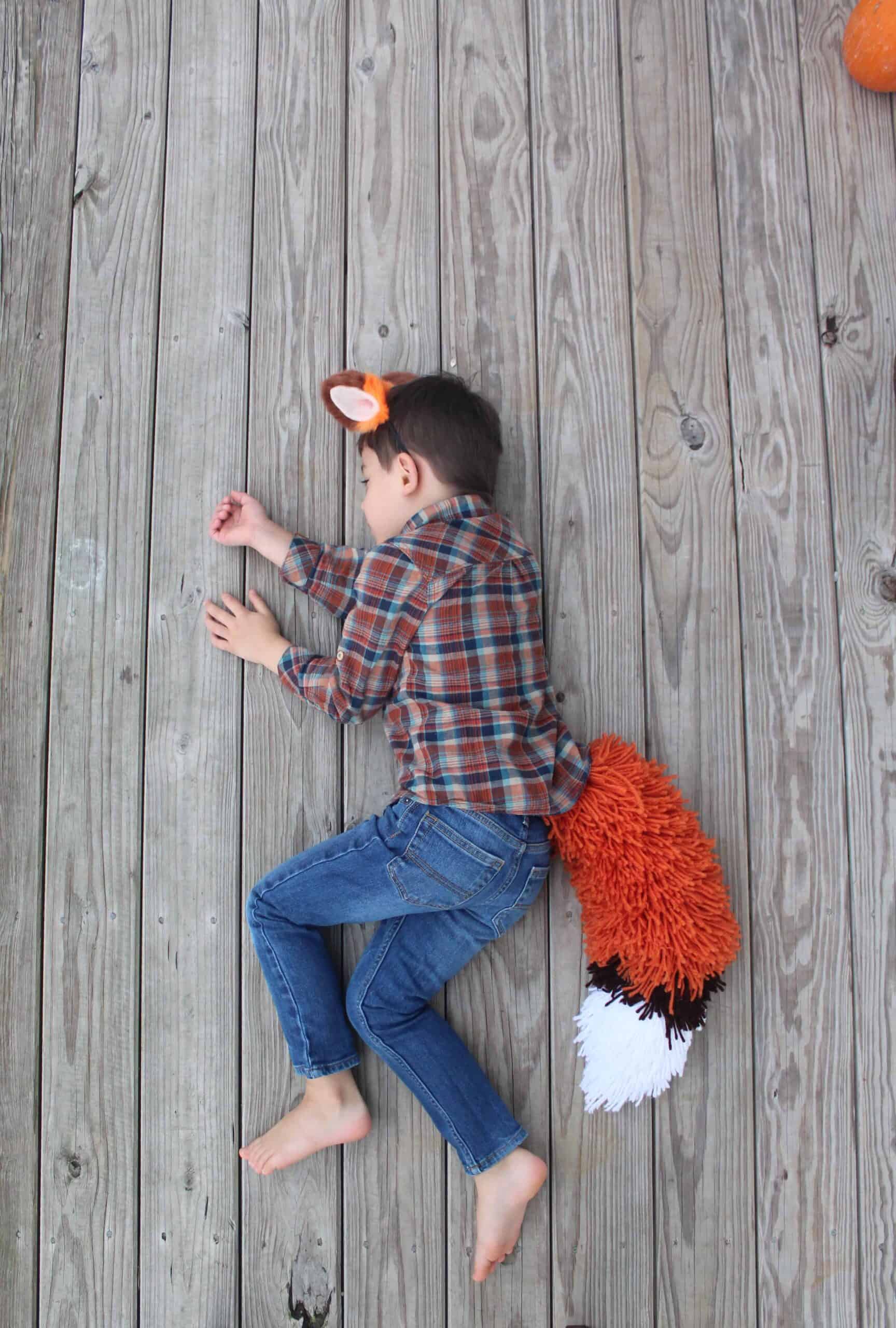 Boy sleeping in his fox tail costume