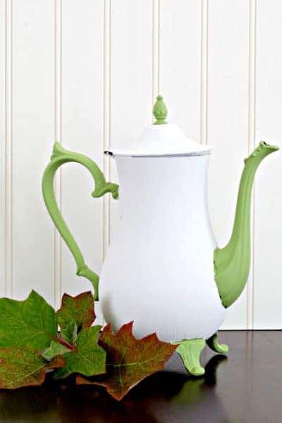A metal teapot chalk painted white