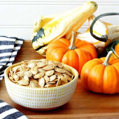 A bowl of pumpkin seeds on a platter