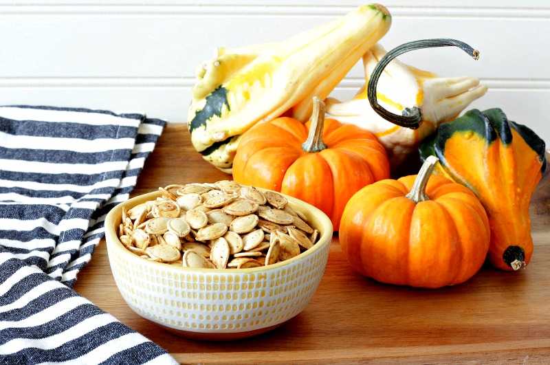 A bowl of pumpkin seeds on a platter