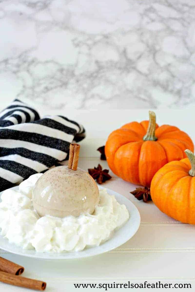 Pumpkin spice latte next to pumpkins on a table