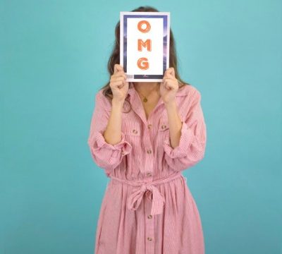 A woman hiding her face, overjoyed to make money blogging