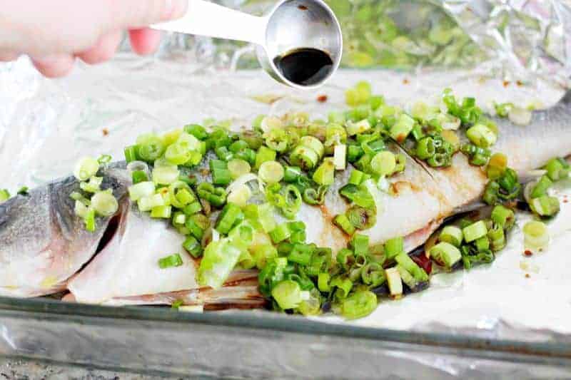 Adding soy sauce to Chinese fish dish