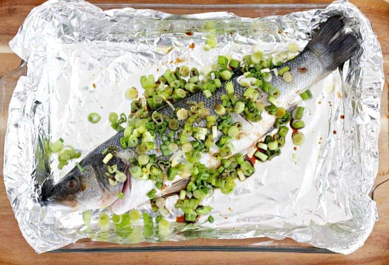 Chinese fish baked in a pan with green onions