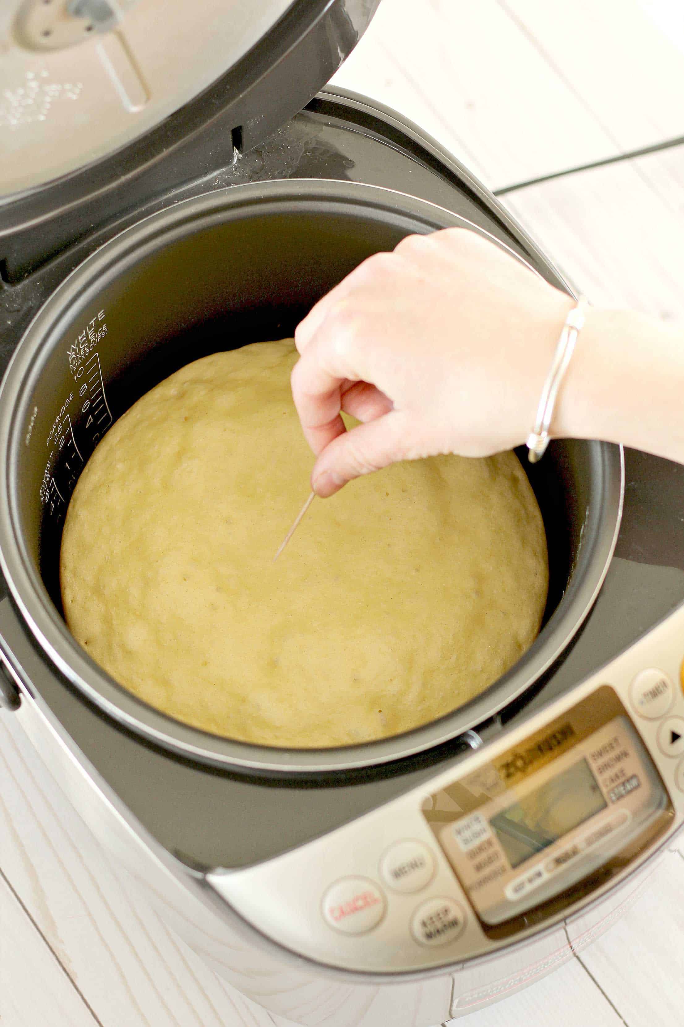 Checking rice cooker pancake with toothpick for doneness