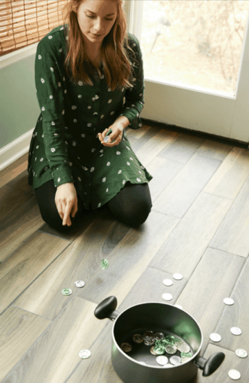 A woman showing kids how to play St. Patrick's Day game