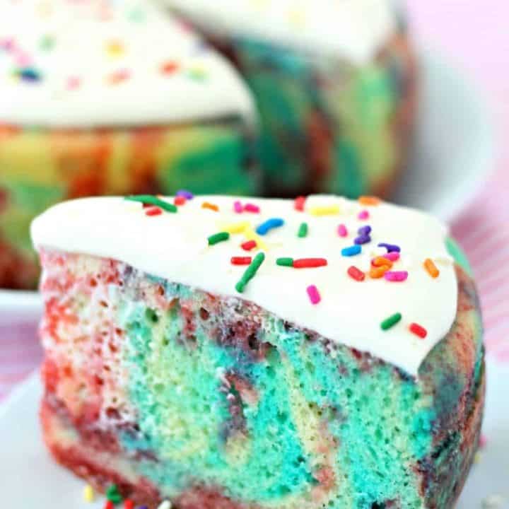 A slice of jello poke cake on a plate with sprinkles