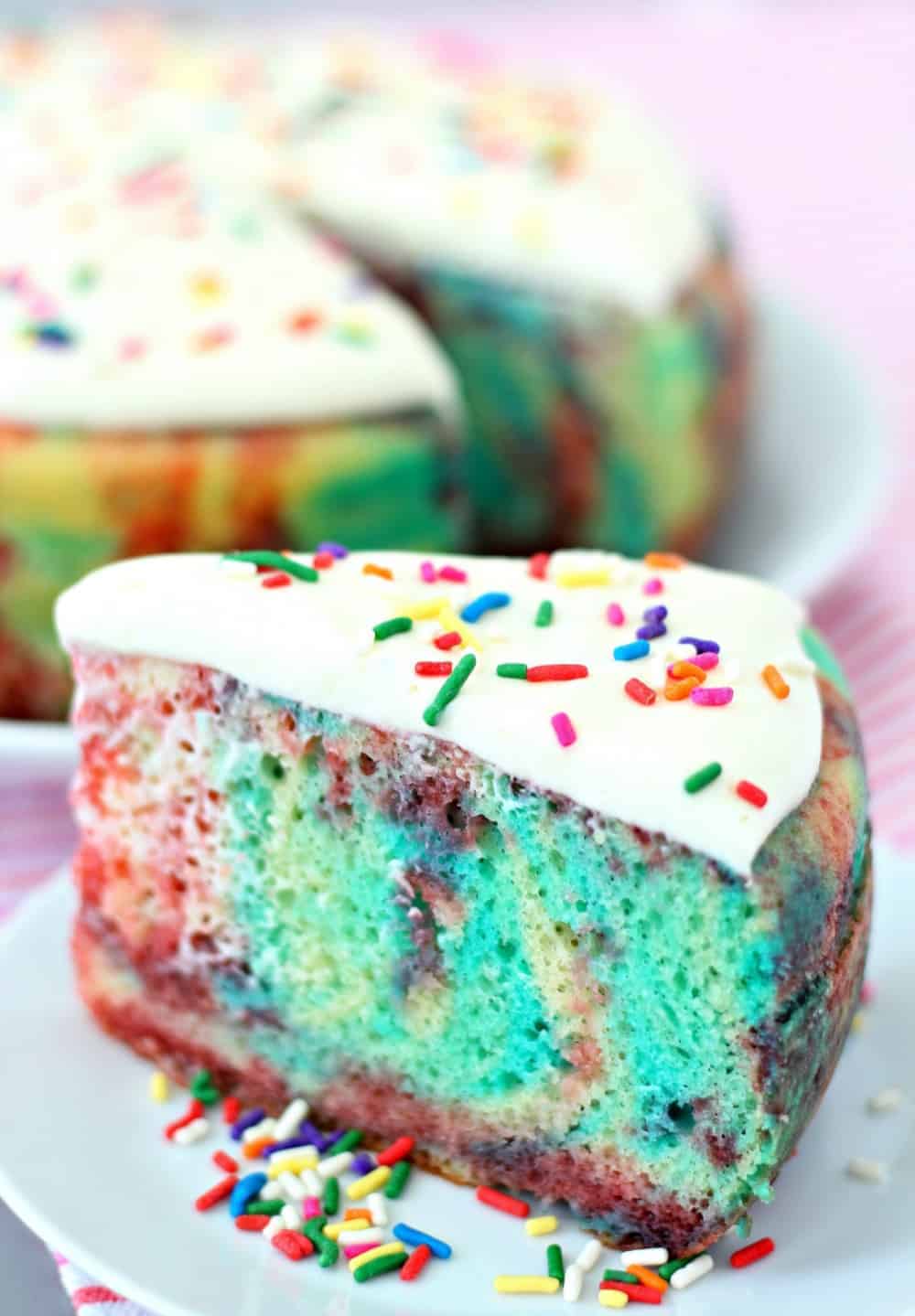 A slice of jello poke cake on a plate with sprinkles