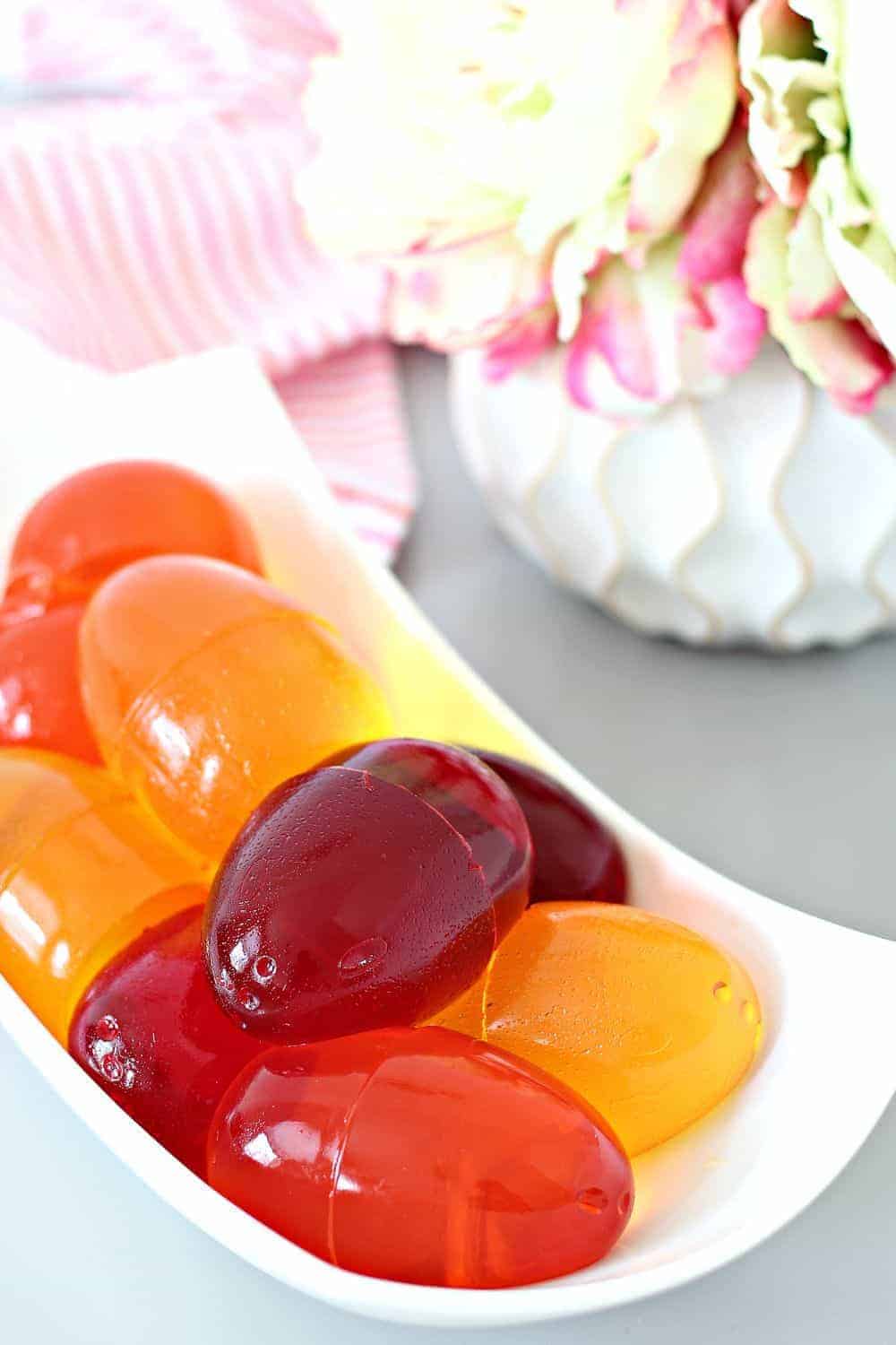 Jello eggs in a bowl next to flowers