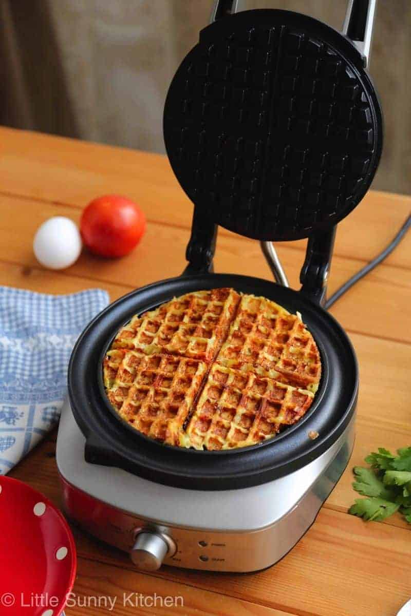 Potatoes and eggs cooking in a waffle iron