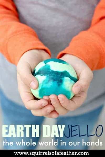 A boy holding a green and blue jello ball