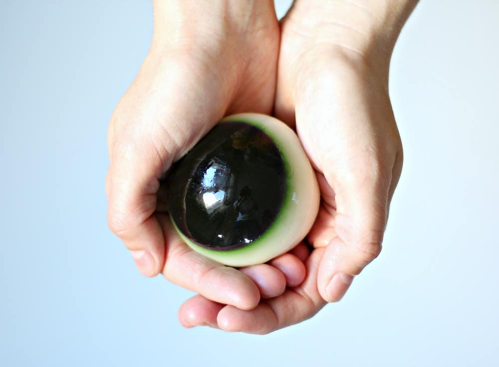 A hand holding an eyeball jello shot.