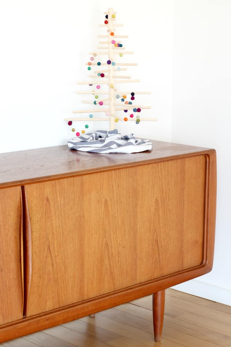 A minimlaist Christmas tree on a modern sideboard