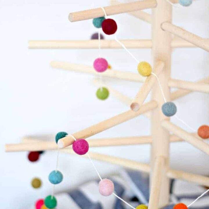 Close up of a felt ball Christmas garland on a wood tree