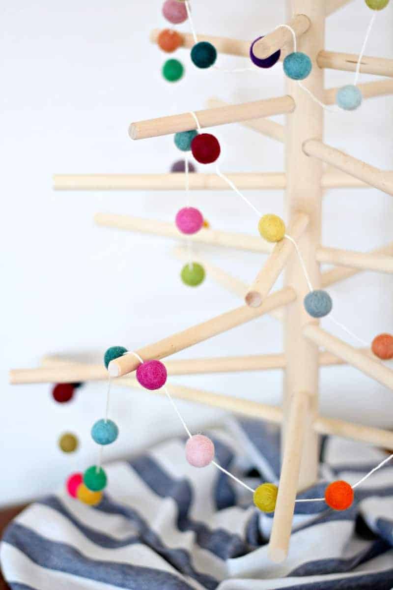 Close up of a felt ball Christmas garland on a wood tree