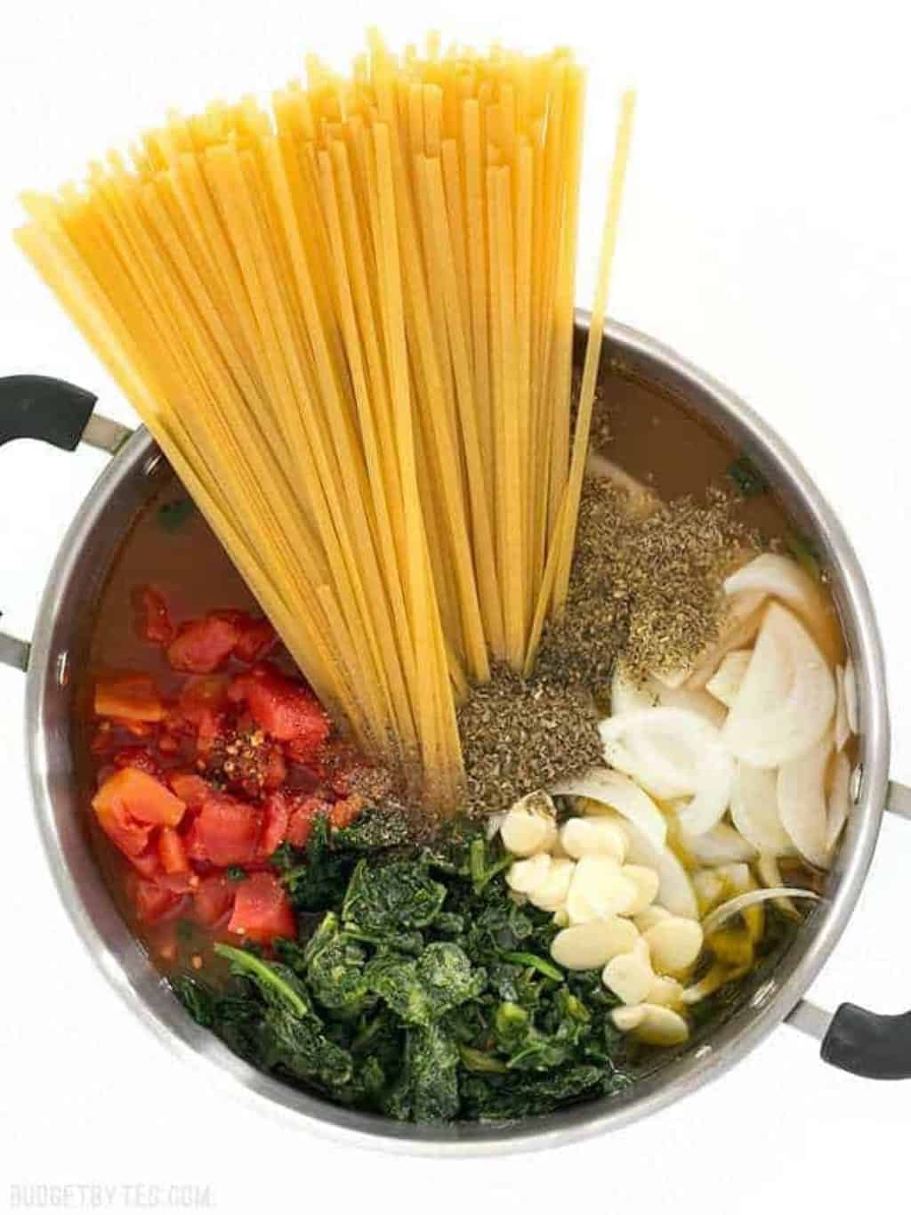 A pot of pasta, veggies and liquid being cooked in one pot