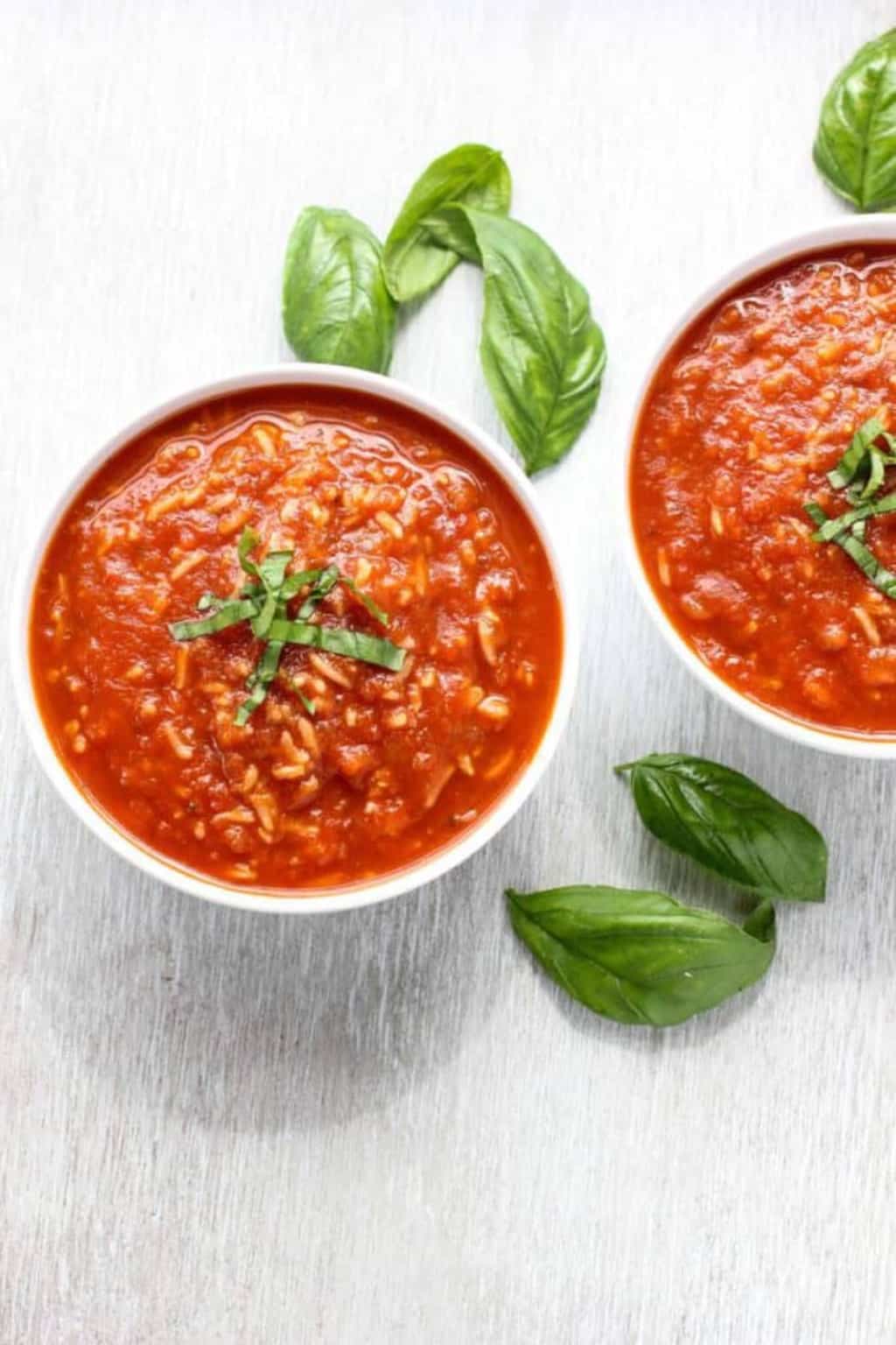 Two bowls of red tomato and rice soup