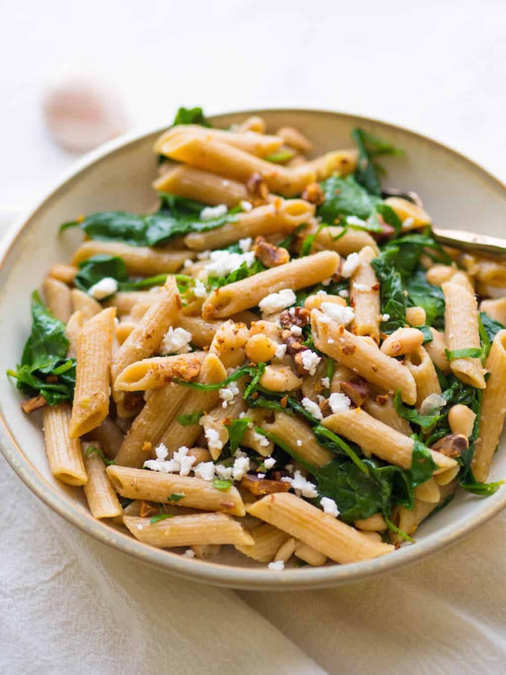 A pasta dish with colorful greens