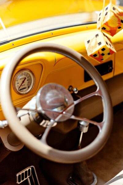 A yellow Uber car with two dice hanging down