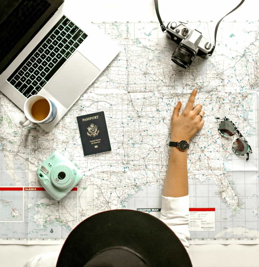 A small travel blogger pointing to a map