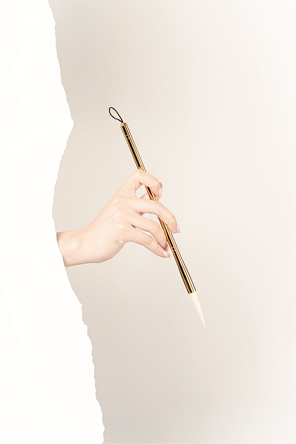 A hand writing a minimalist shopping list with a gold pen