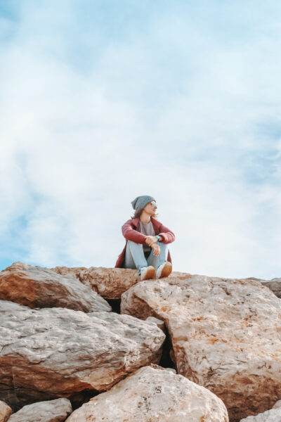 An ambition woman reading quotes sitting on a rock