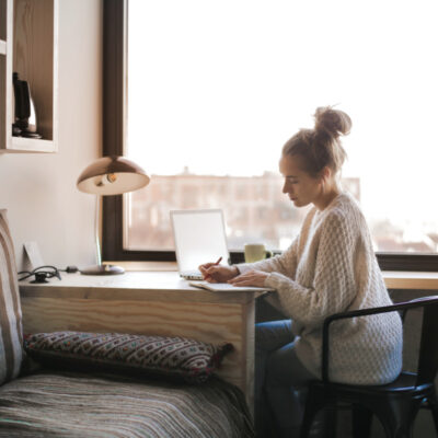 A woman writing SMART goals by a windown