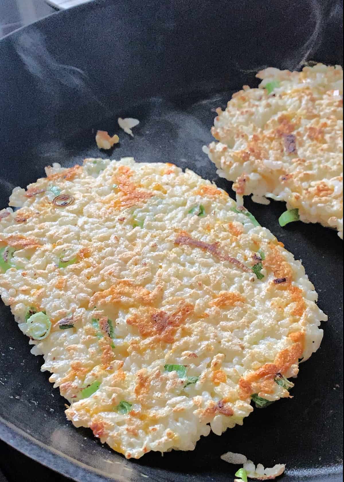 close up of two rice pancakes in a pan